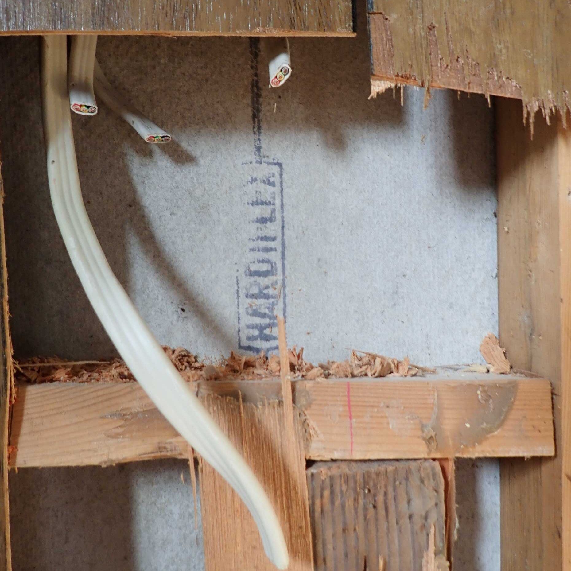 Asbestos cement wall hidden behind plywood wall