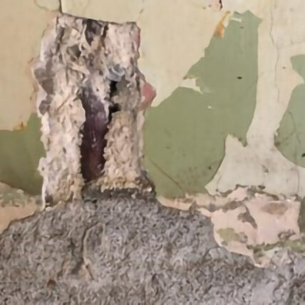 Asbestos pipe insulation revealed behind plaster and ceramic tiles