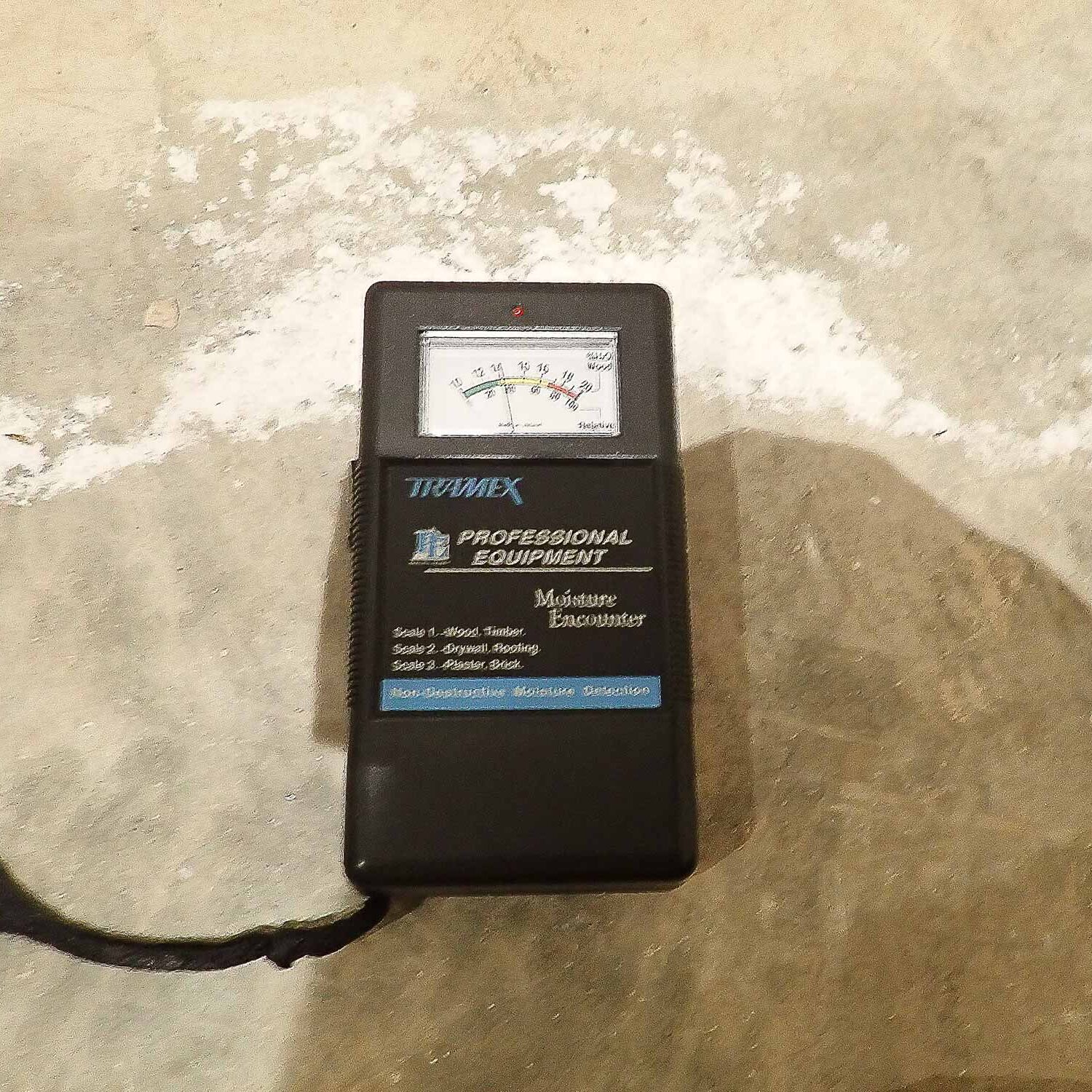 Efflorescence on concrete slab with moisture level reading